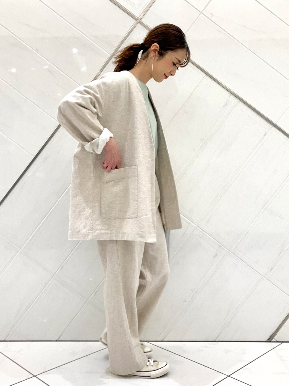 グリーン系のTシャツ/カットソー、ホワイト系のスニーカー、ベージュ系のノーカラージャケットを着用したレディースの春コーディネートの1枚目の写真