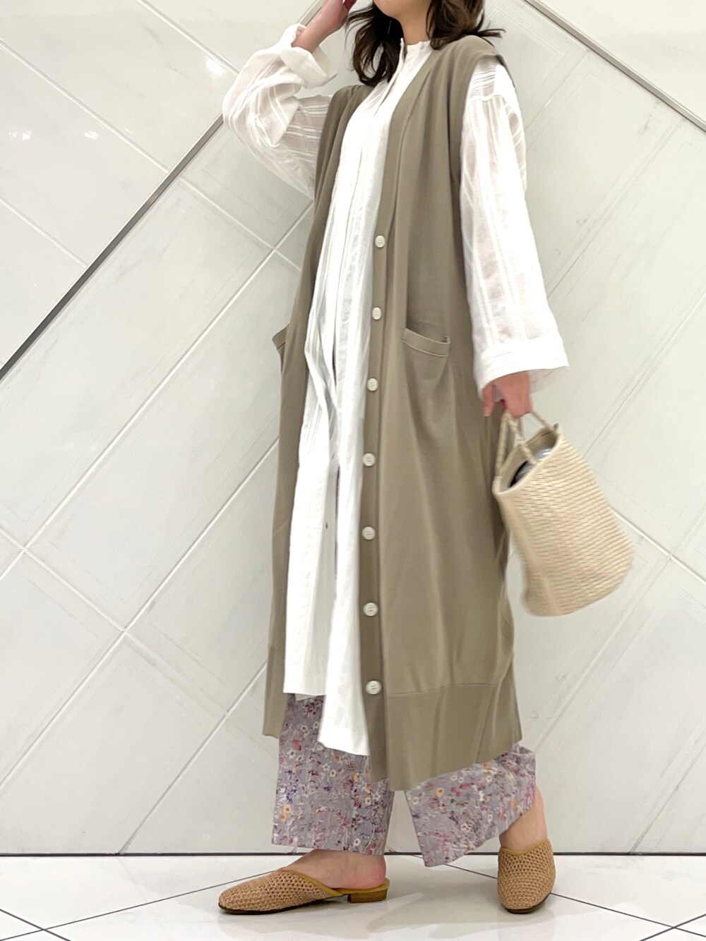 ベージュ系のニット/セーター、グレー系のその他パンツ、ホワイト系のワンピースを着用したレディースの春コーディネートの1枚目の写真