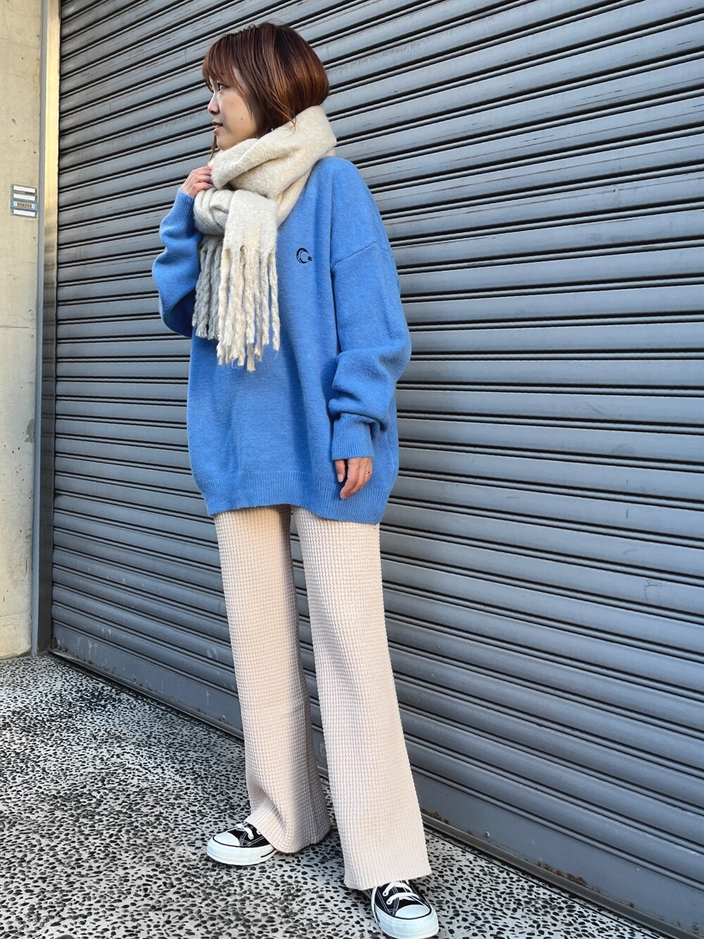 ブルー系のニット/セーター、ホワイト系のその他パンツ、ブラック系のスニーカーを着用したレディースの冬コーディネートの1枚目の写真
