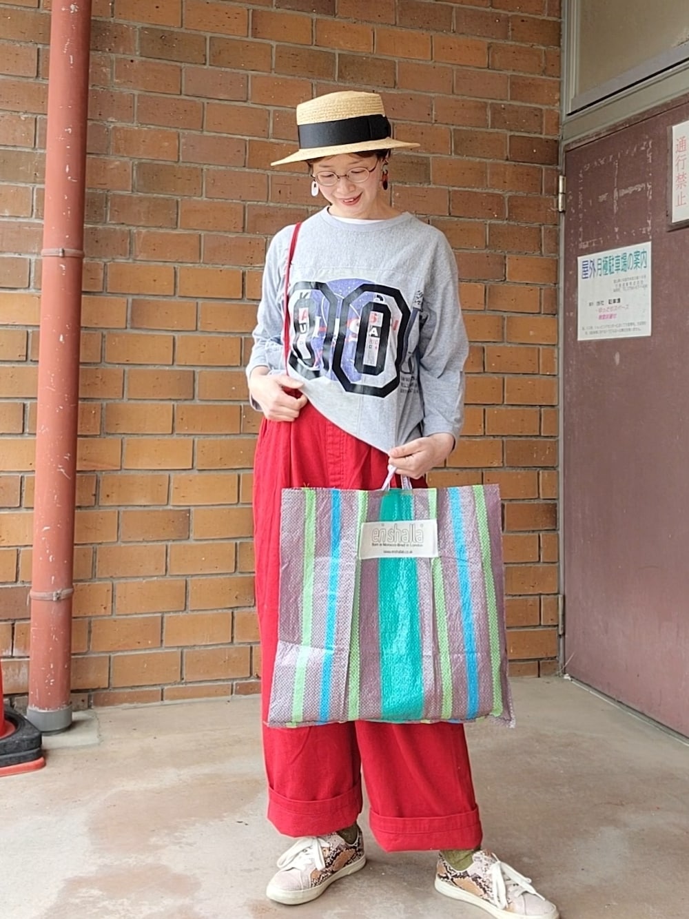 グレー系のTシャツ/カットソー、レッド系のその他パンツ、その他のトートバッグを着用したレディースの春コーディネートの1枚目の写真