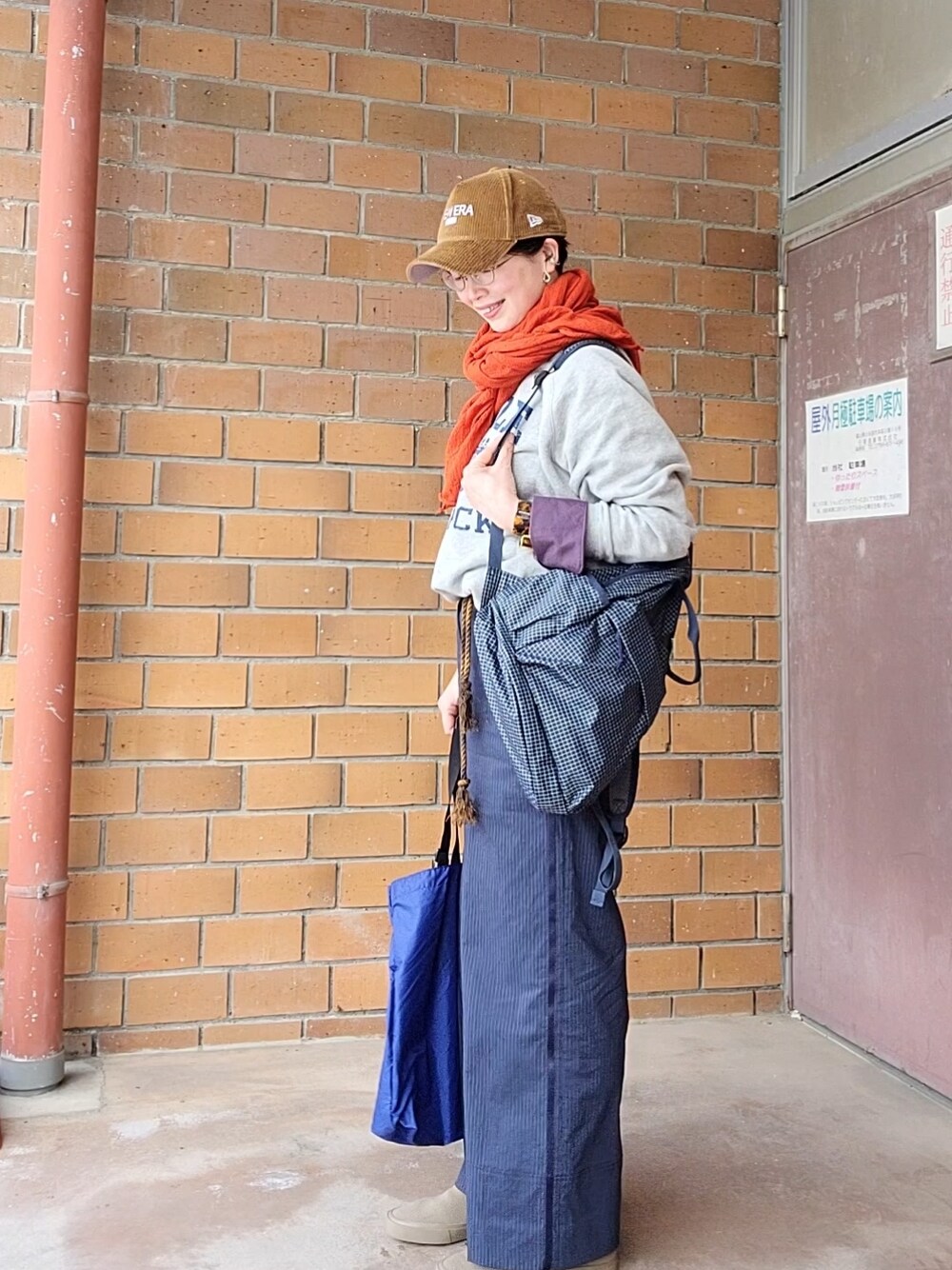 グレー系のスウェット、ブルー系のバックパック/リュック、ブルー系のエコバッグ/サブバッグを着用したレディースの春コーディネートの3枚目の写真