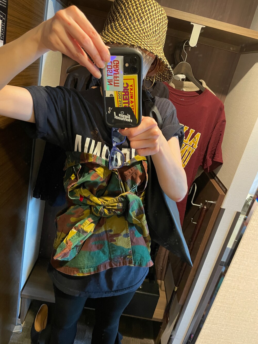 グリーン系のミリタリージャケット、ブラック系のTシャツ/カットソー、ブラック系のハットを着用したレディースの春コーディネートの1枚目の写真