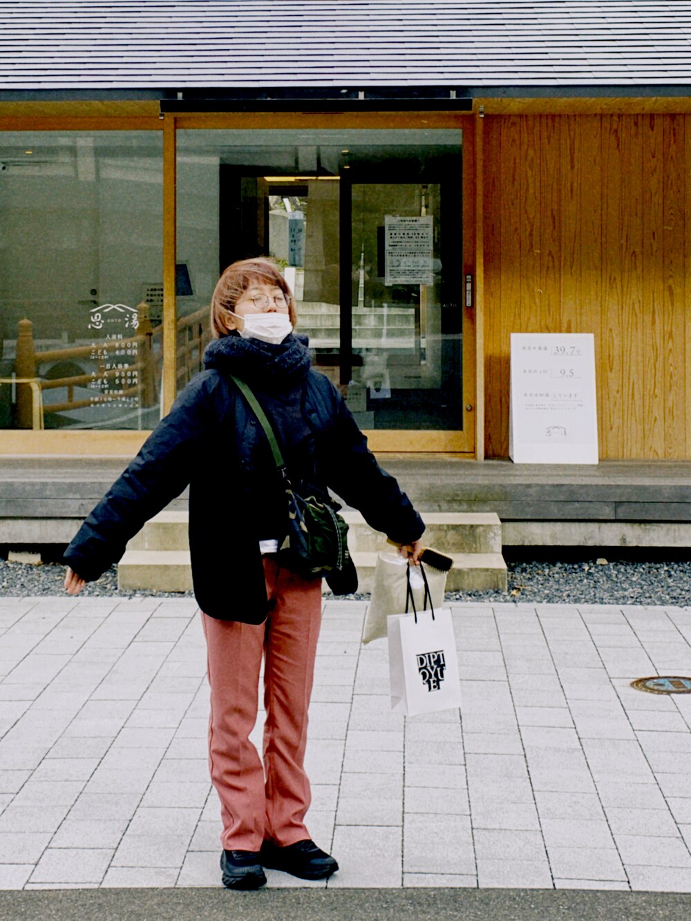 ピンク系のその他パンツ、グリーン系のショルダーバッグ、ブラック系のダウンジャケット/コートを着用したレディースの冬コーディネートの1枚目の写真