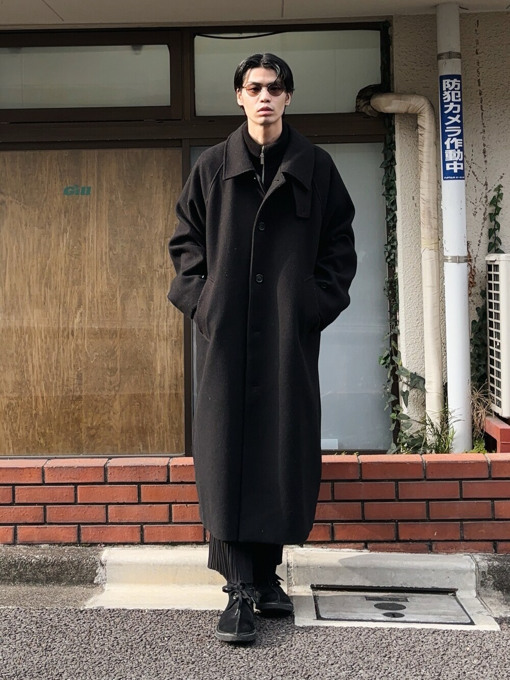 「真冬のあったかスタイル、ドライバーズニット、ロングコート、コート、サングラス、プリーツパンツ、ワラビー、革靴、モード、ワントーンコーデ、オールブラック、ブラック、シンプルスタイル、休日スタイル、きれいめカジュアル」｜「seytoのCircle punching damage drivers knit / サークルパンチングダメージドライバーズニット（ニット/セーター、ブラック系）」を使った、Takuya  Kobayashiさん（メンズ・176cm）の冬コーディネートの1枚目の写真