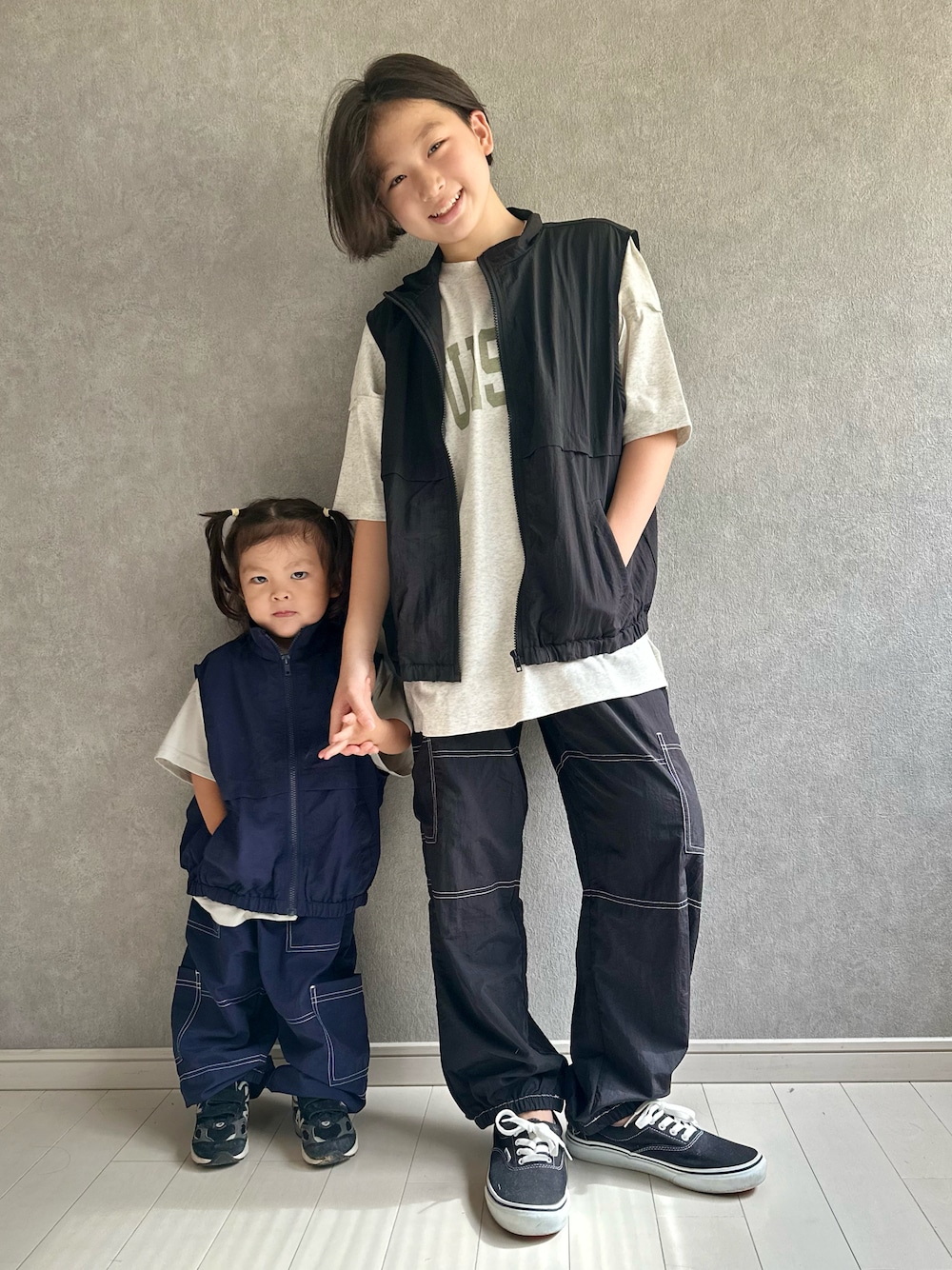 ベージュ系のTシャツ/カットソー、ブラック系のベスト、ブラック系のスニーカーを着用したキッズの夏コーディネートの1枚目の写真