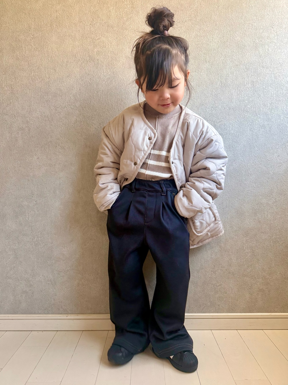 ベージュ系のブルゾン、ベージュ系のニット/セーター、ブルー系のその他パンツを着用したキッズの冬コーディネートの1枚目の写真