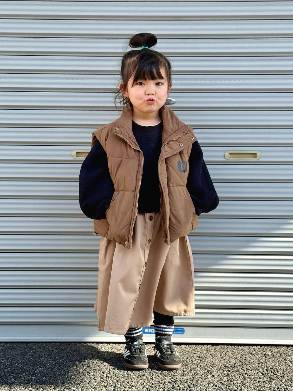 「PR、休日スタイル、カジュアル、ダウンベスト、ワンピース、スニーカー、チョコ色に染まれ、ブラウン、ドッキングワンピ、ikka」｜「ikkaのフクレジャカードドッキングスカートワンピース（120~160cm）（ワンピース、ブラック系）」を使った、kii_memeさん（キッズ・151cm）の冬コーディネートの1枚目の写真