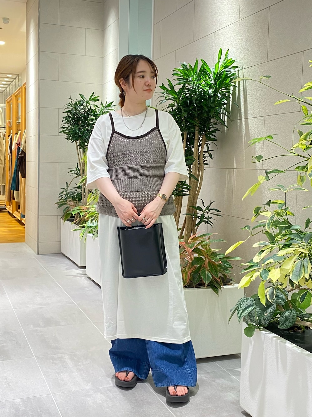 グレー系のワンピース、ブルー系のニット/セーター、ブルー系のデニムパンツを着用したレディースの夏コーディネートの1枚目の写真