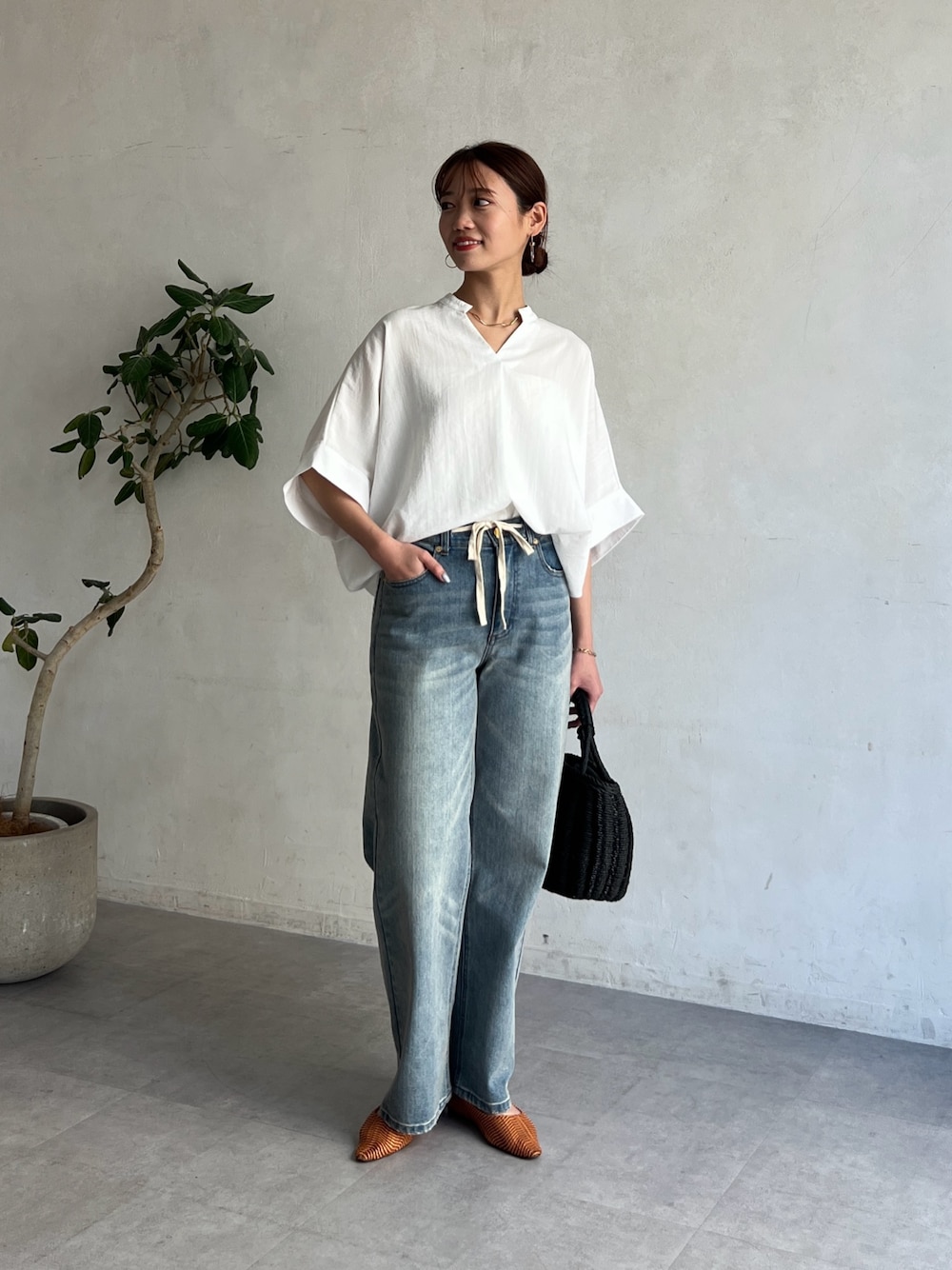 ホワイト系のシャツ/ブラウス、ブルー系のデニムパンツ、ブラック系のかごバッグを着用したレディースの春コーディネートの1枚目の写真