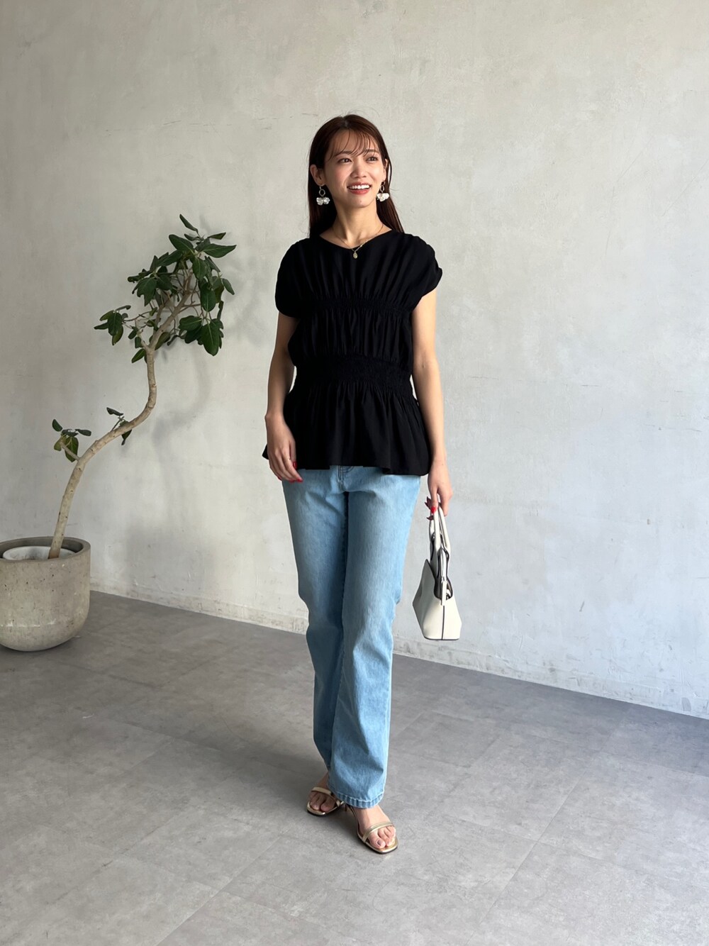 ブラック系のシャツ/ブラウス、ブルー系のデニムパンツを着用したレディースの春コーディネートの1枚目の写真