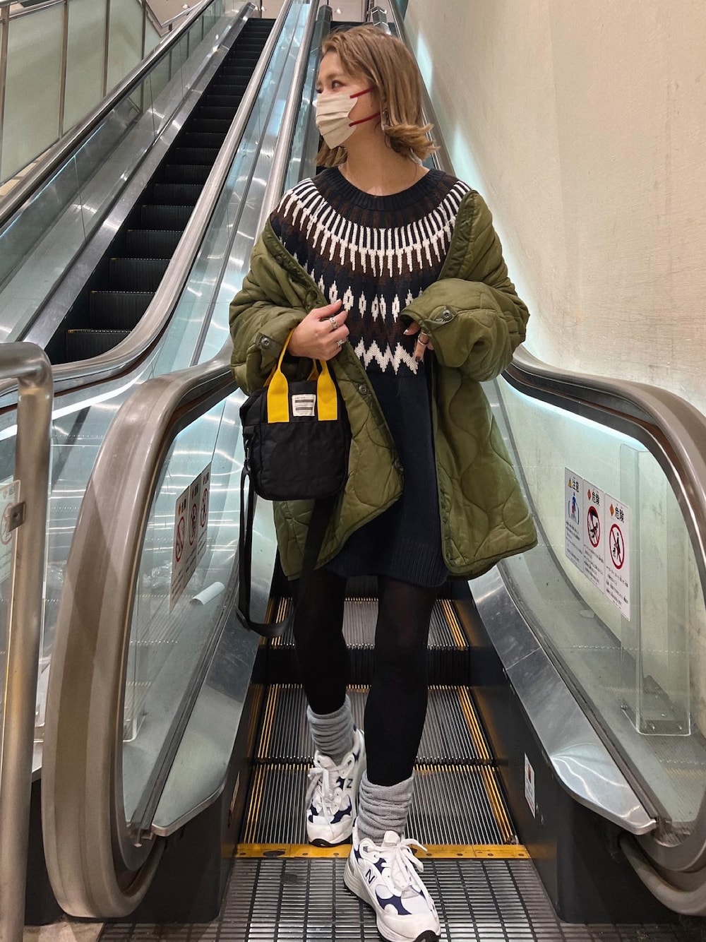 ブラック系のトートバッグ、グリーン系のジャケット/アウター、ホワイト系のスニーカーを着用したレディースの冬コーディネートの1枚目の写真