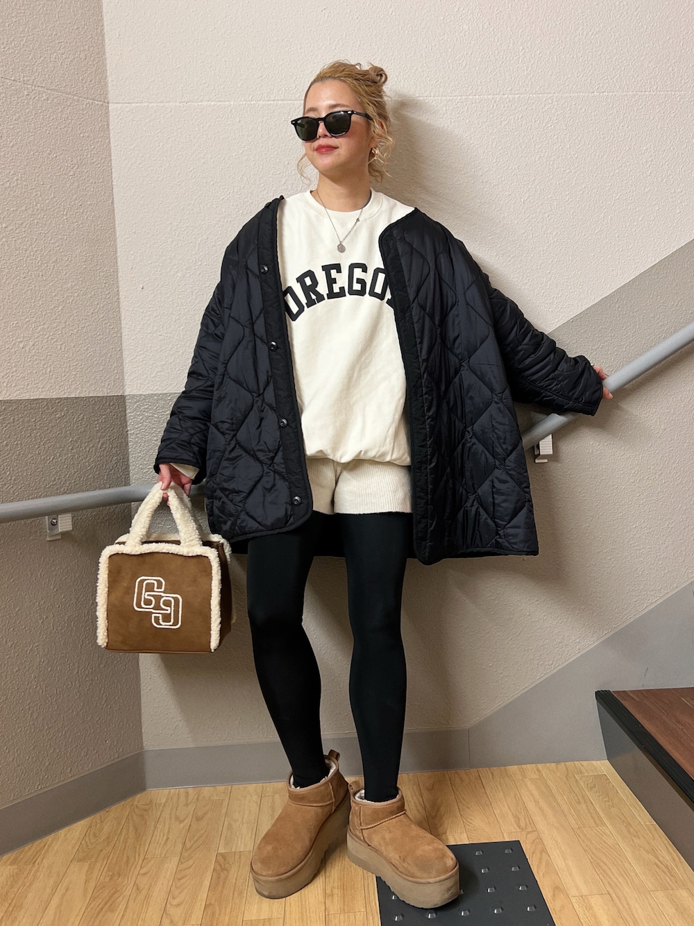 ブラウン系のトートバッグ、ホワイト系のスウェット、ホワイト系のパンツを着用したレディースの冬コーディネートの1枚目の写真