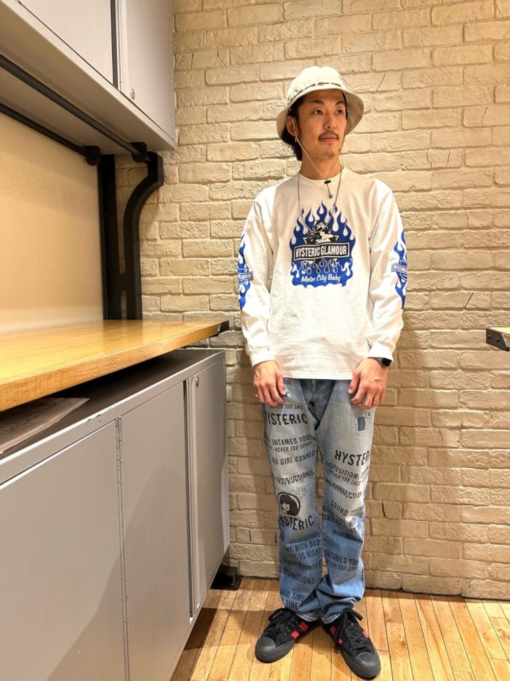 ブルー系のデニムパンツ、ホワイト系のTシャツ/カットソー、ベージュ系のハットを着用したメンズの冬コーディネートの1枚目の写真