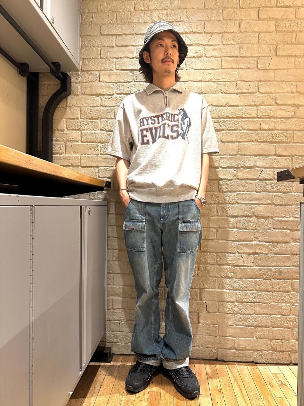 ブルー系のデニムパンツ、グレー系のスウェット、グリーン系のハットを着用したメンズの春コーディネートの1枚目の写真