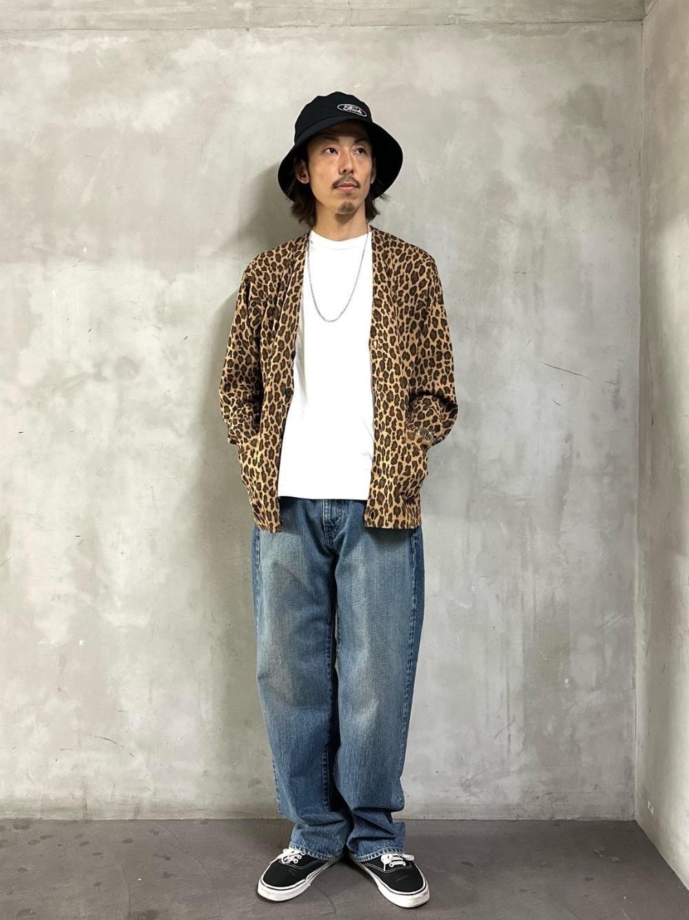 ホワイト系のTシャツ/カットソー、ベージュ系のカーディガン/ボレロ、ブルー系のデニムパンツを着用したメンズの春コーディネートの1枚目の写真