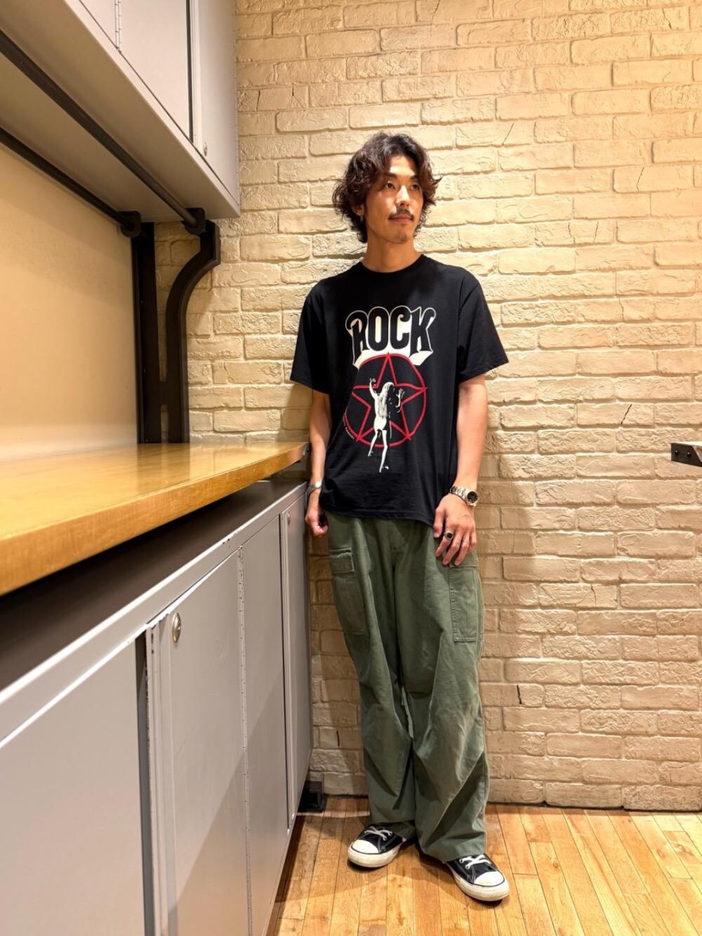 グリーン系のカーゴパンツ、ブラック系のTシャツ/カットソーを着用したメンズの夏コーディネートの1枚目の写真