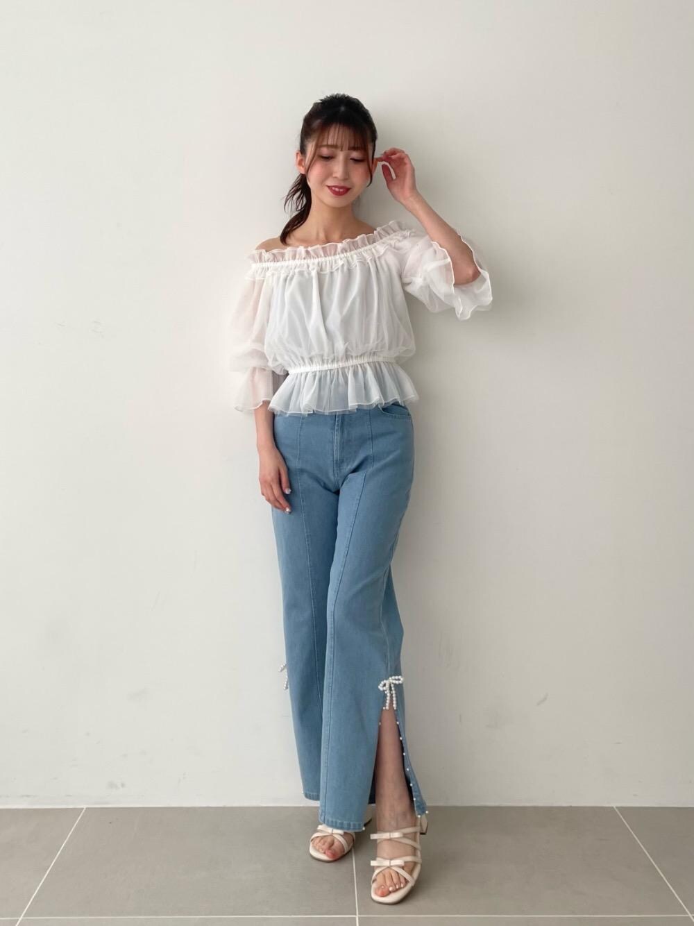 ブルー系のデニムパンツ、ホワイト系のサンダル、ホワイト系のシャツ/ブラウスを着用したレディースの春コーディネートの1枚目の写真