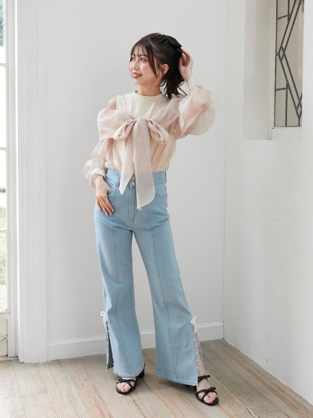ブルー系のデニムパンツ、ブラック系のサンダルを着用したレディースの春コーディネートの1枚目の写真