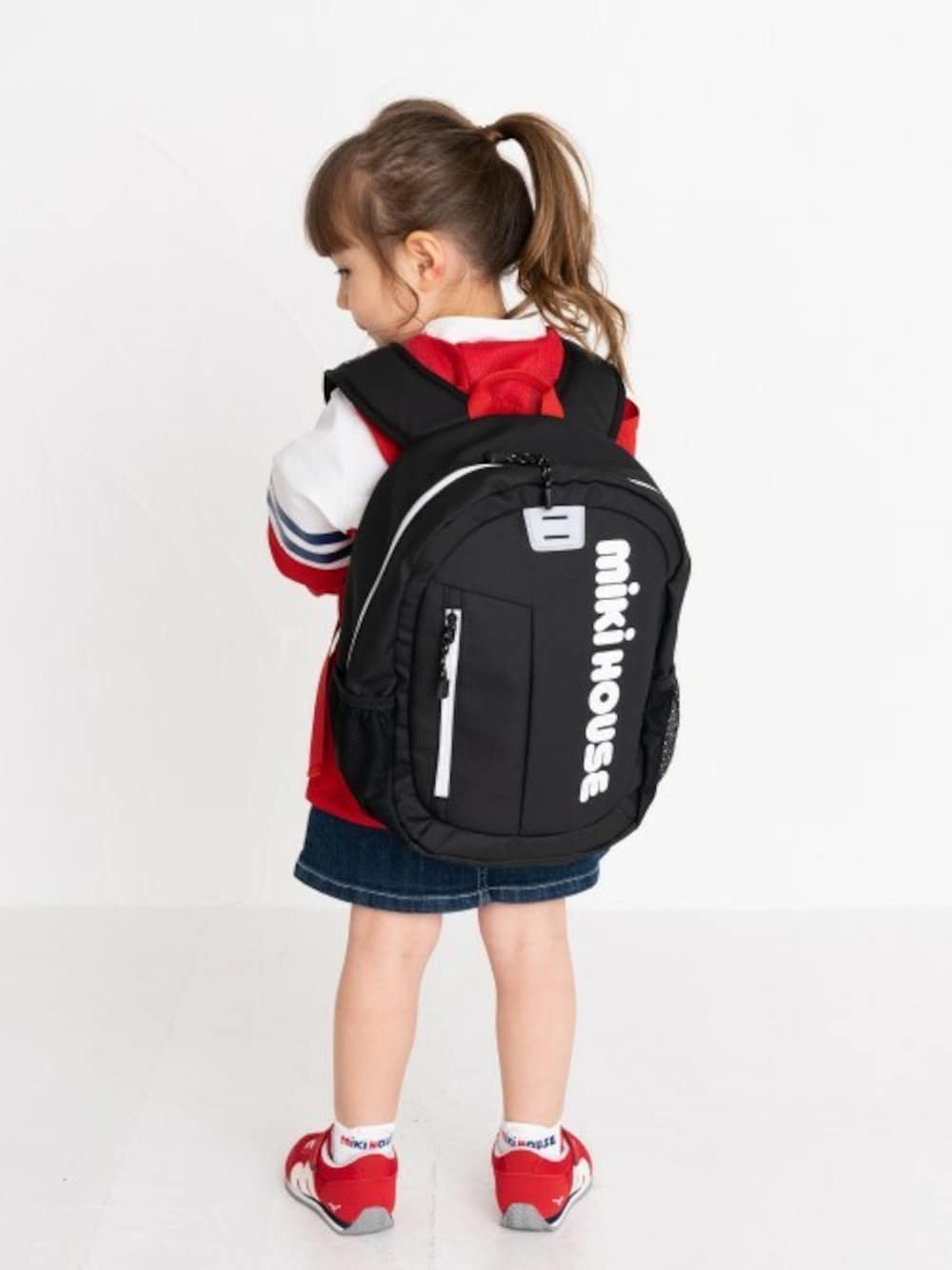 「スニーカー、リュック、アウトドアスタイル、デニムスカート、ロゴ、スポーツミックス、キッズコーデ、カジュアルコーデ、ミキハウス、キッズファッション」｜「MIKI HOUSEのロゴリュック（バックパック/リュック、ブラック系）」を使った、ミキハウス担当者２さん（キッズ・98cm）の秋コーディネートの1枚目の写真