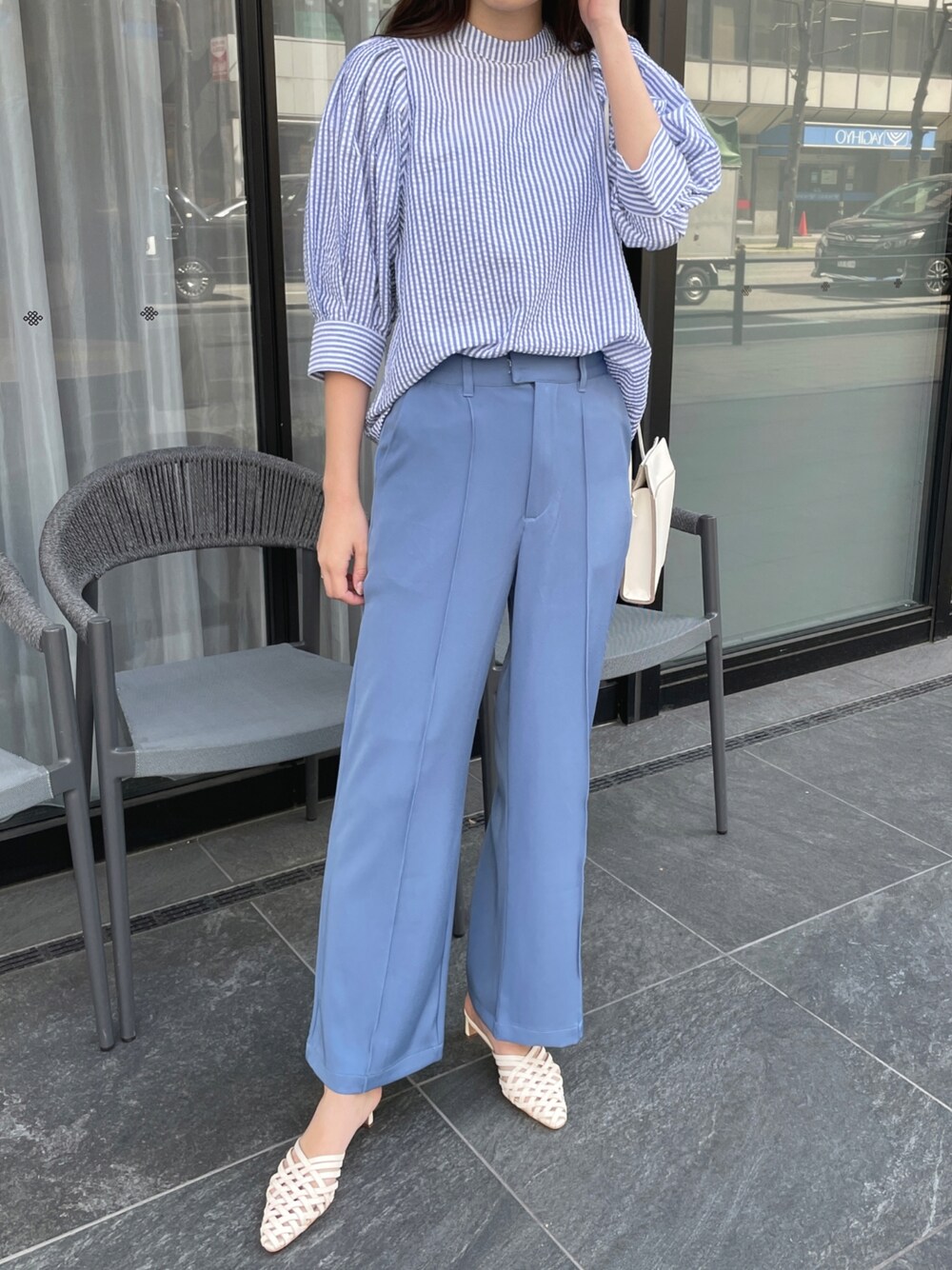 ブルー系のシャツ/ブラウス、ブルー系のスラックス、ホワイト系のサンダルを着用したレディースの春コーディネートの1枚目の写真