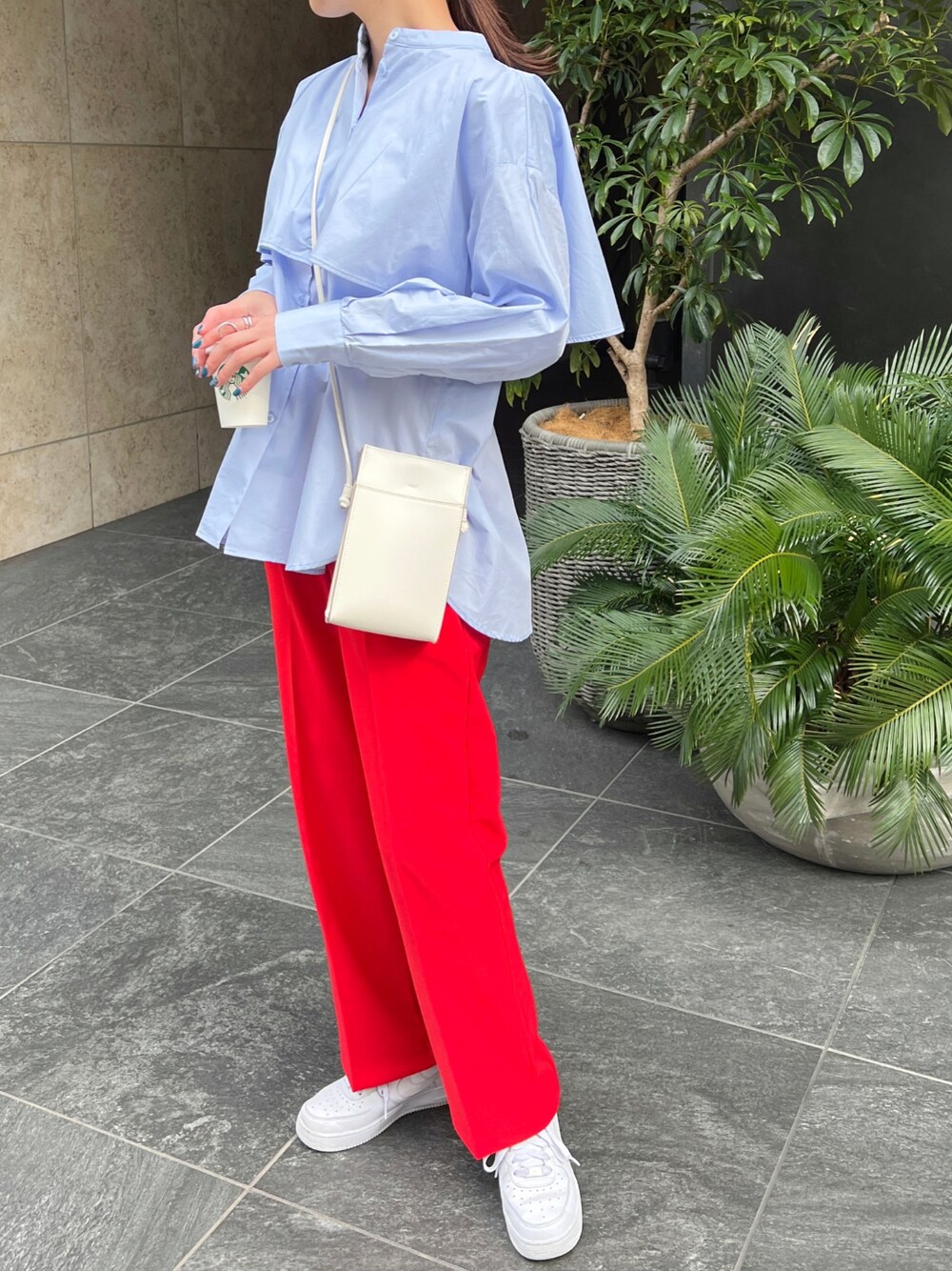 ブルー系のシャツ/ブラウス、レッド系のスラックスを着用したレディースの春コーディネートの1枚目の写真