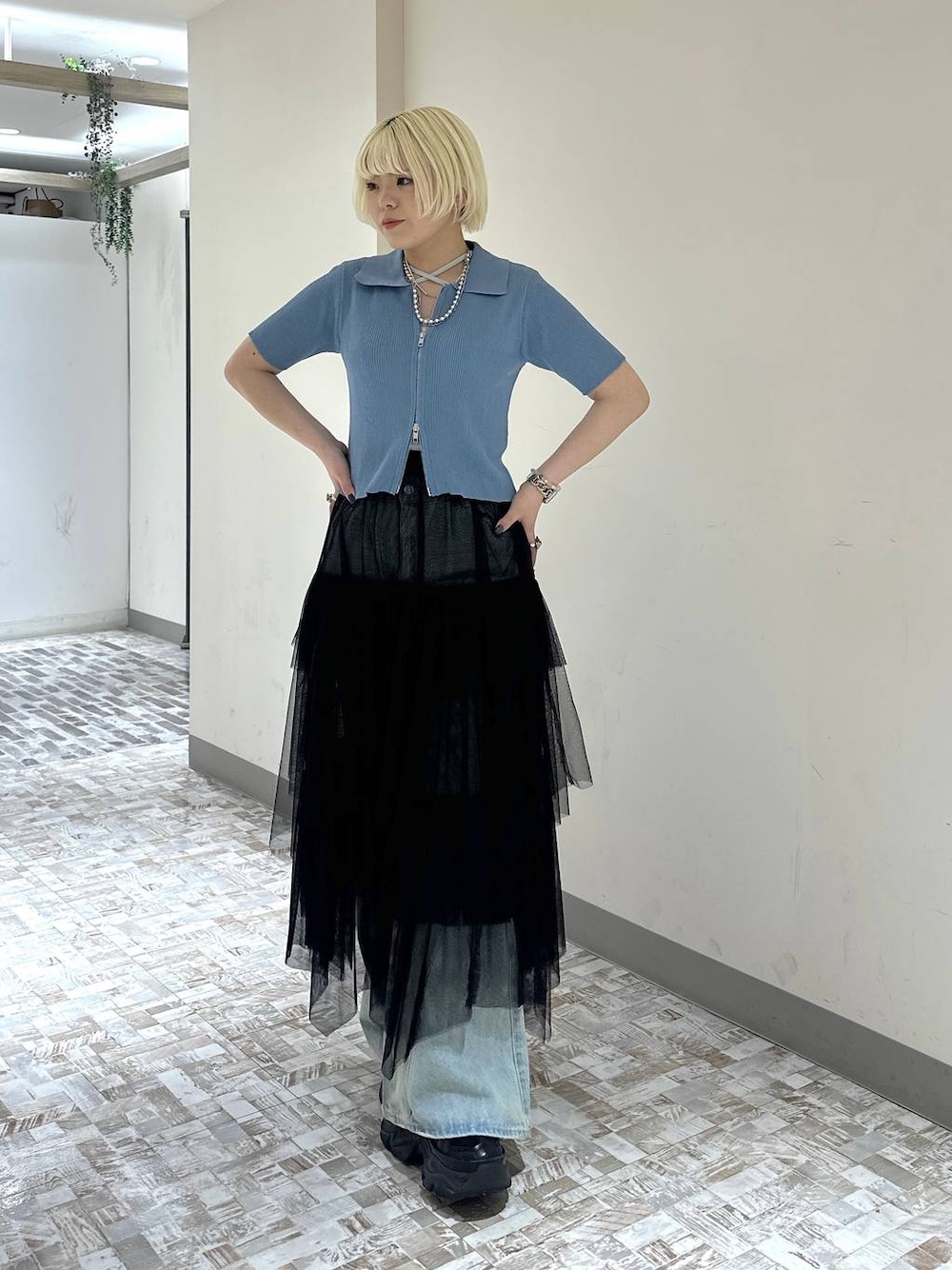 ブラック系のスニーカー、ブルー系のデニムパンツ、ブラック系のスカートを着用したレディースの春コーディネートの1枚目の写真