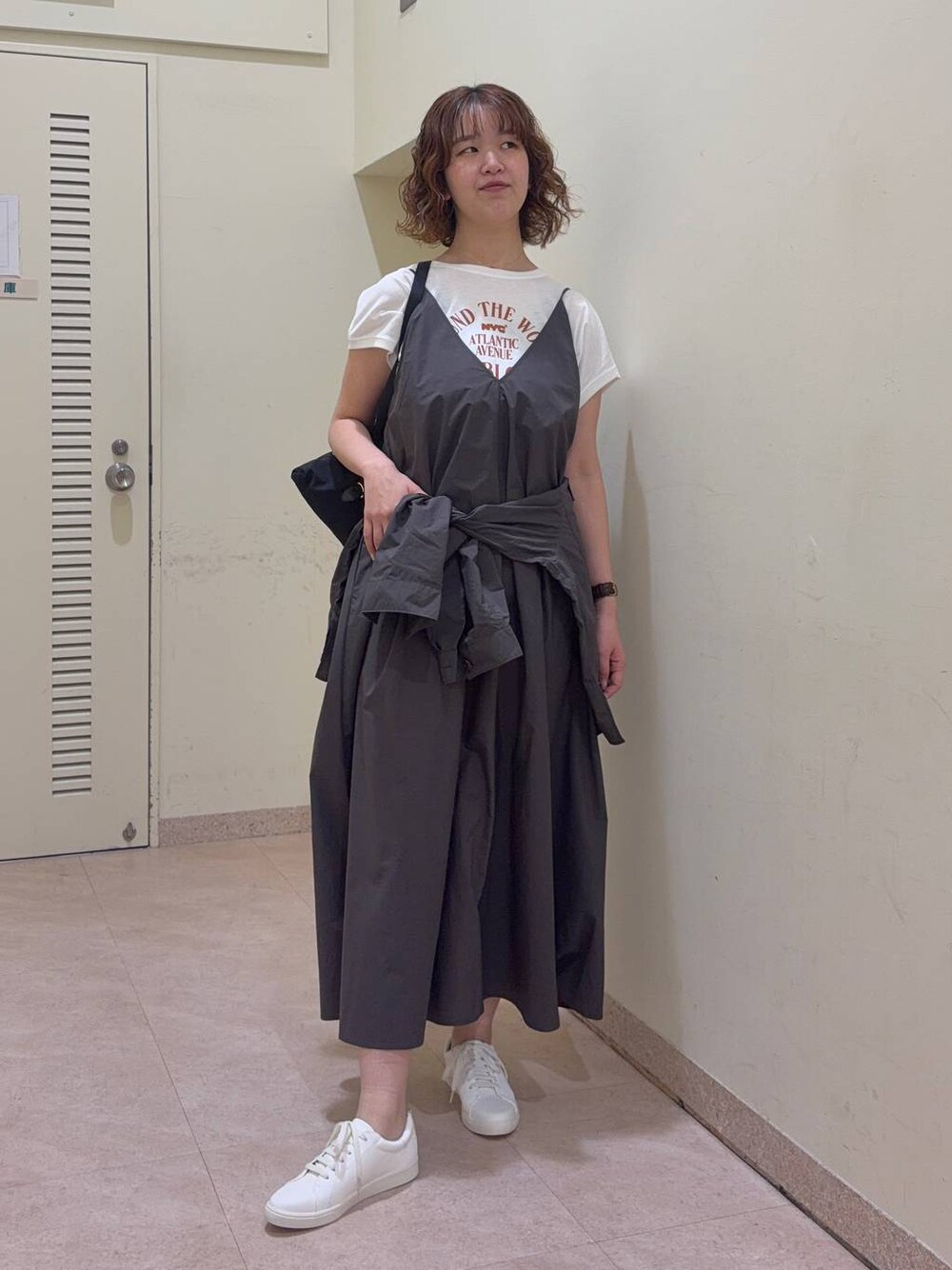グレー系のシャツ/ブラウス、ホワイト系のTシャツ/カットソー、ブラック系のバックパック/リュックを着用したレディースの春コーディネートの1枚目の写真