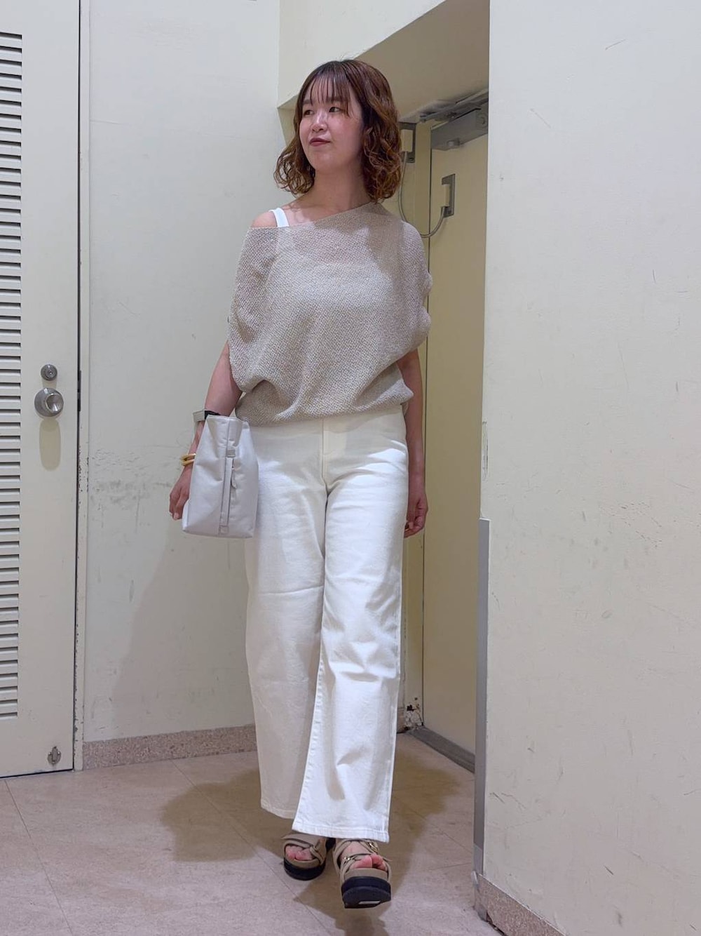 ホワイト系のデニムパンツ、ホワイト系のトートバッグ、ホワイト系のタンクトップを着用したレディースの夏コーディネートの1枚目の写真