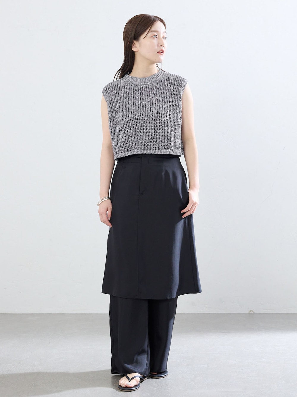 ブラック系のその他パンツ、グレー系のベスト、ブラック系のサンダルを着用したレディースの夏コーディネートの1枚目の写真