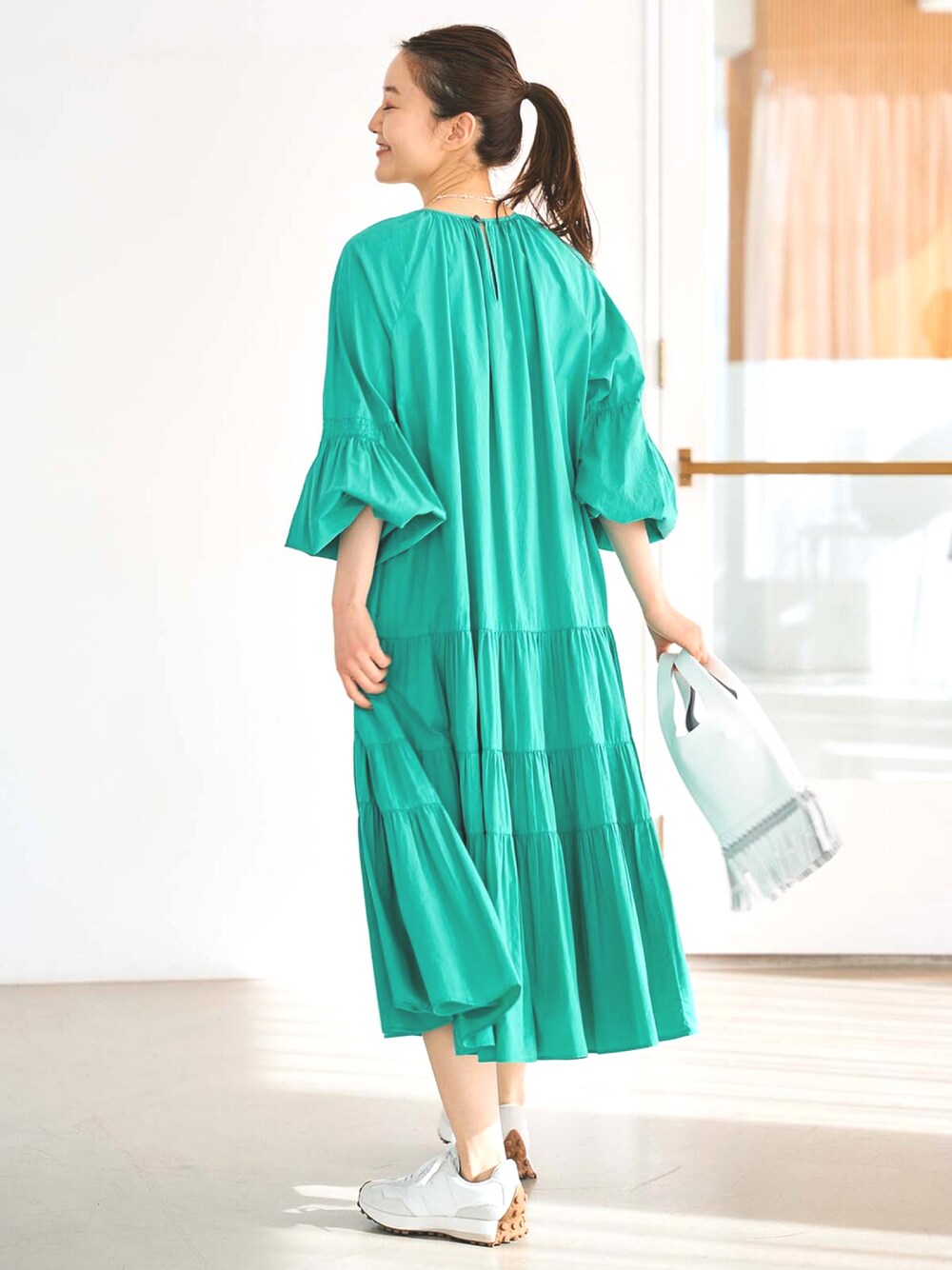 グリーン系のワンピースを着用したレディースの冬コーディネートの1枚目の写真