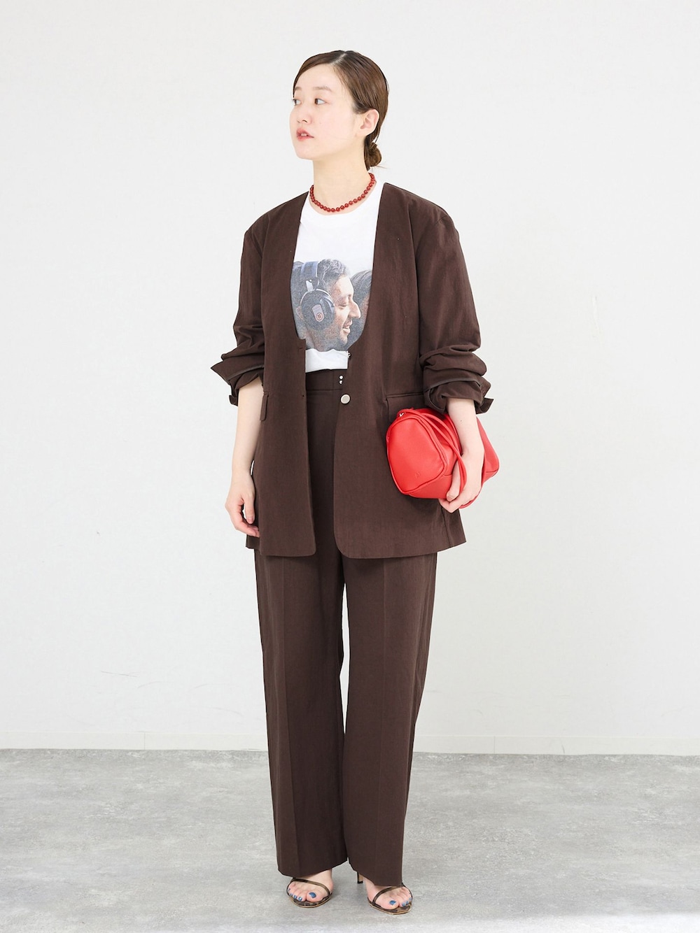 ブラウン系のノーカラージャケット、ブラウン系のスラックス、ホワイト系のTシャツ/カットソーを着用したレディースの春コーディネートの1枚目の写真