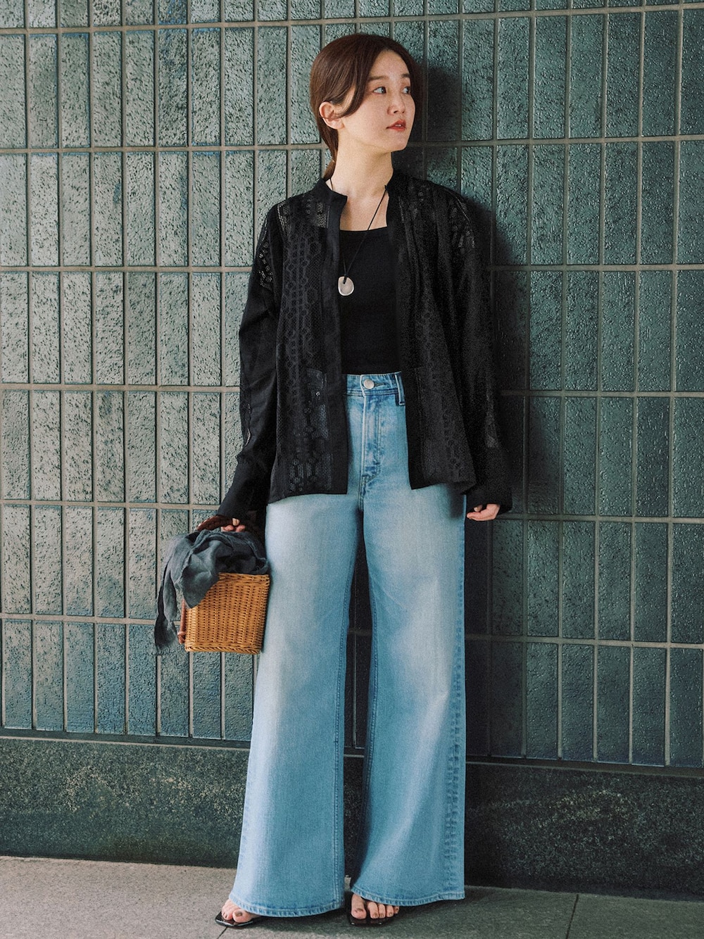 ブルー系のデニムパンツ、ブラック系のシャツ/ブラウス、イエロー系のハンドバッグを着用したレディースの夏コーディネートの1枚目の写真