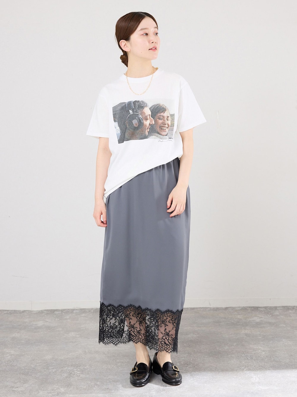 グレー系のスカート、ホワイト系のTシャツ/カットソー、ブラック系のローファーを着用したレディースの春コーディネートの1枚目の写真