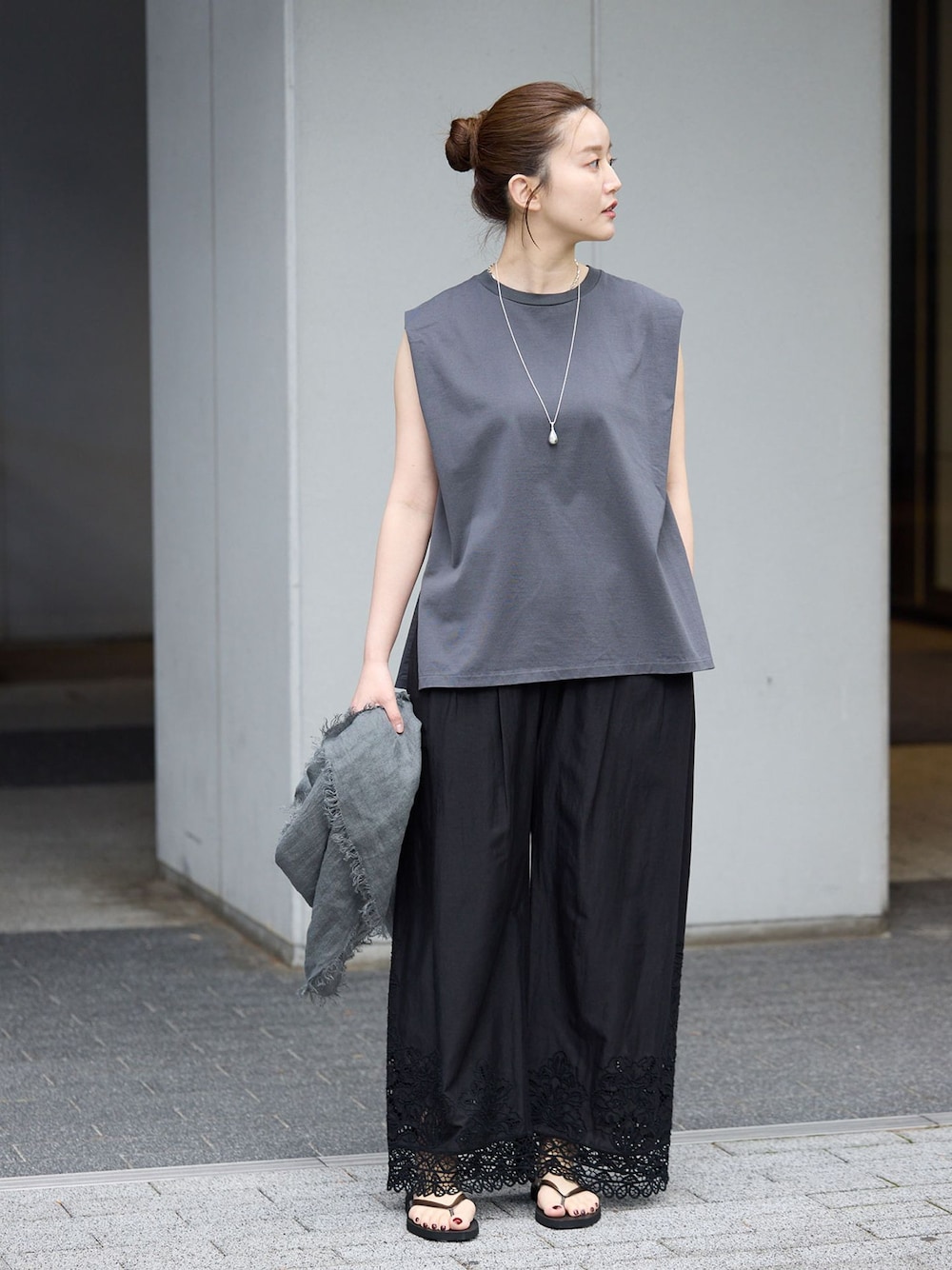 ブラック系のその他パンツ、グレー系のTシャツ/カットソー、ブラック系のサンダルを着用したレディースの春コーディネートの1枚目の写真