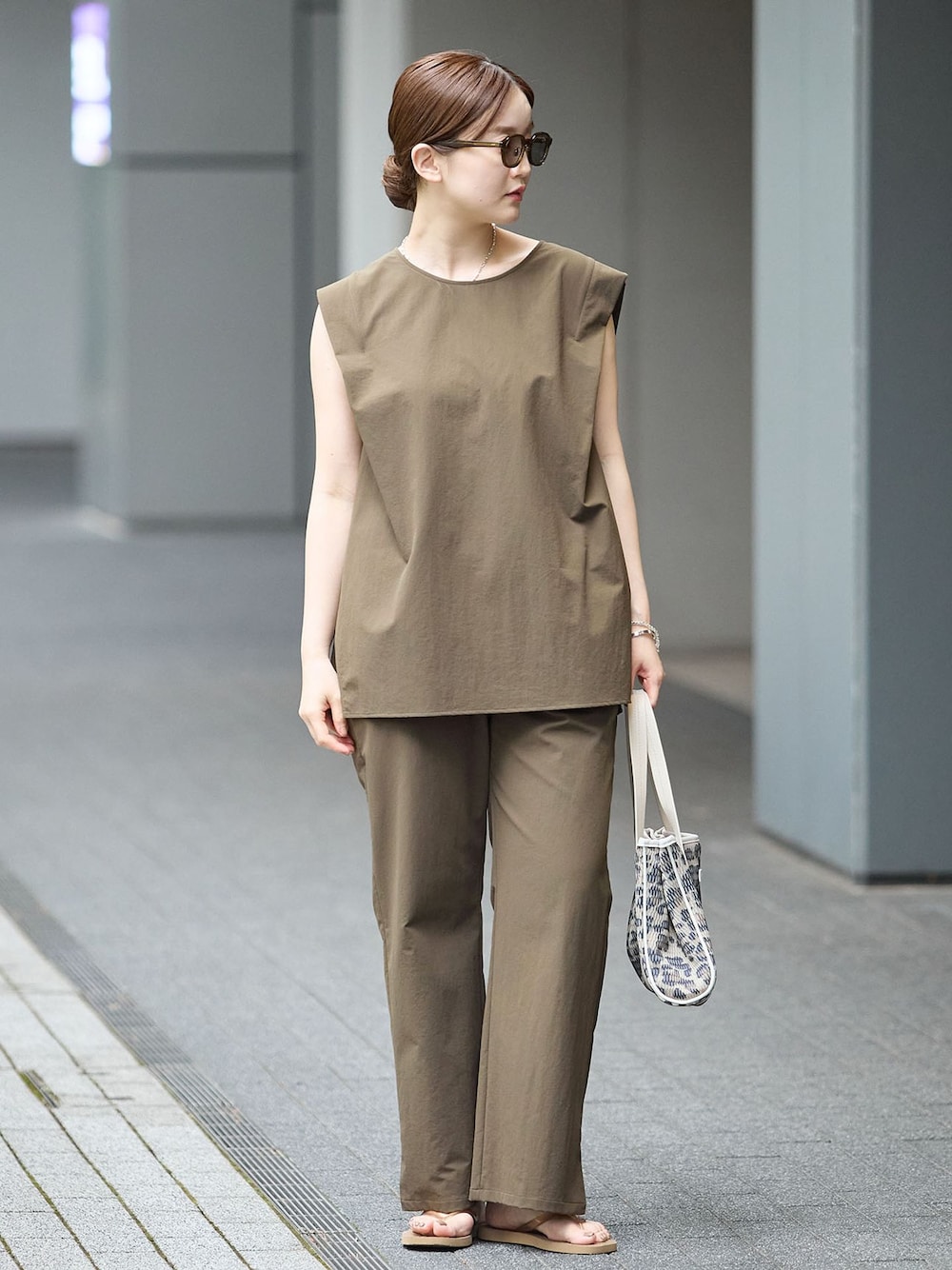 グリーン系のその他パンツ、グリーン系のTシャツ/カットソー、ベージュ系のサンダルを着用したレディースの夏コーディネートの1枚目の写真