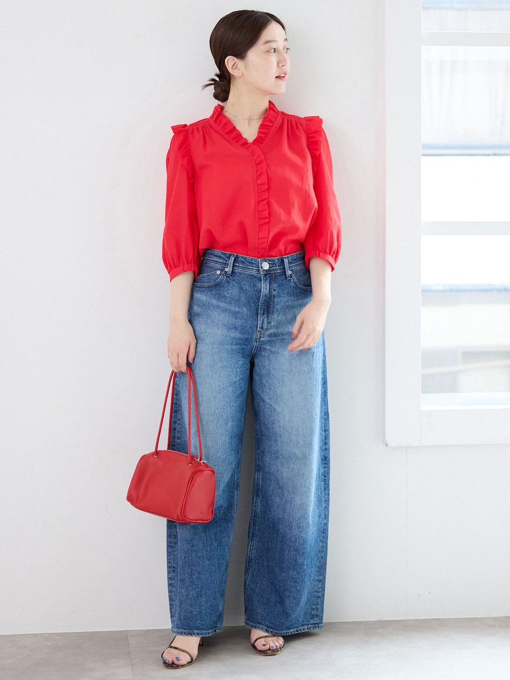 ブルー系のデニムパンツ、レッド系のシャツ/ブラウス、レッド系のショルダーバッグを着用したレディースの春コーディネートの1枚目の写真