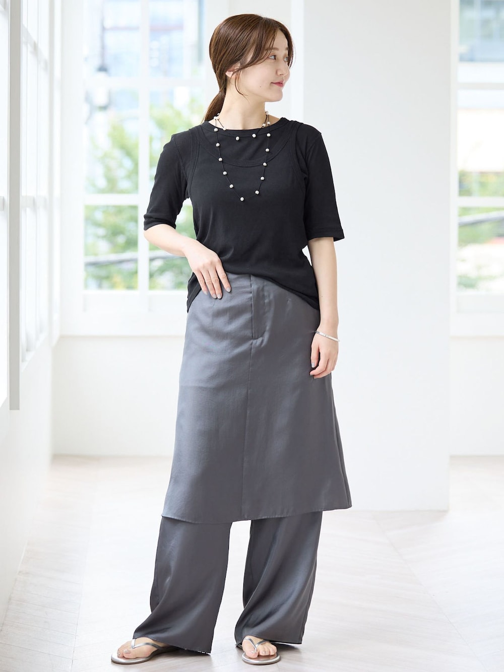 グレー系のその他パンツ、ブラック系のTシャツ/カットソー、シルバー系のサンダルを着用したレディースの夏コーディネートの1枚目の写真
