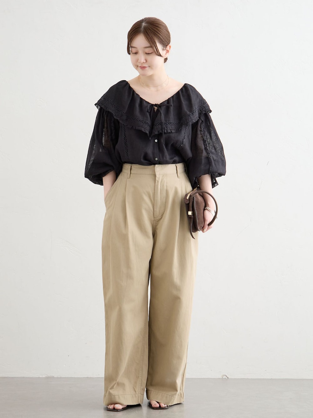 ベージュ系のチノパンツ、ブラック系のシャツ/ブラウスを着用したレディースの夏コーディネートの1枚目の写真