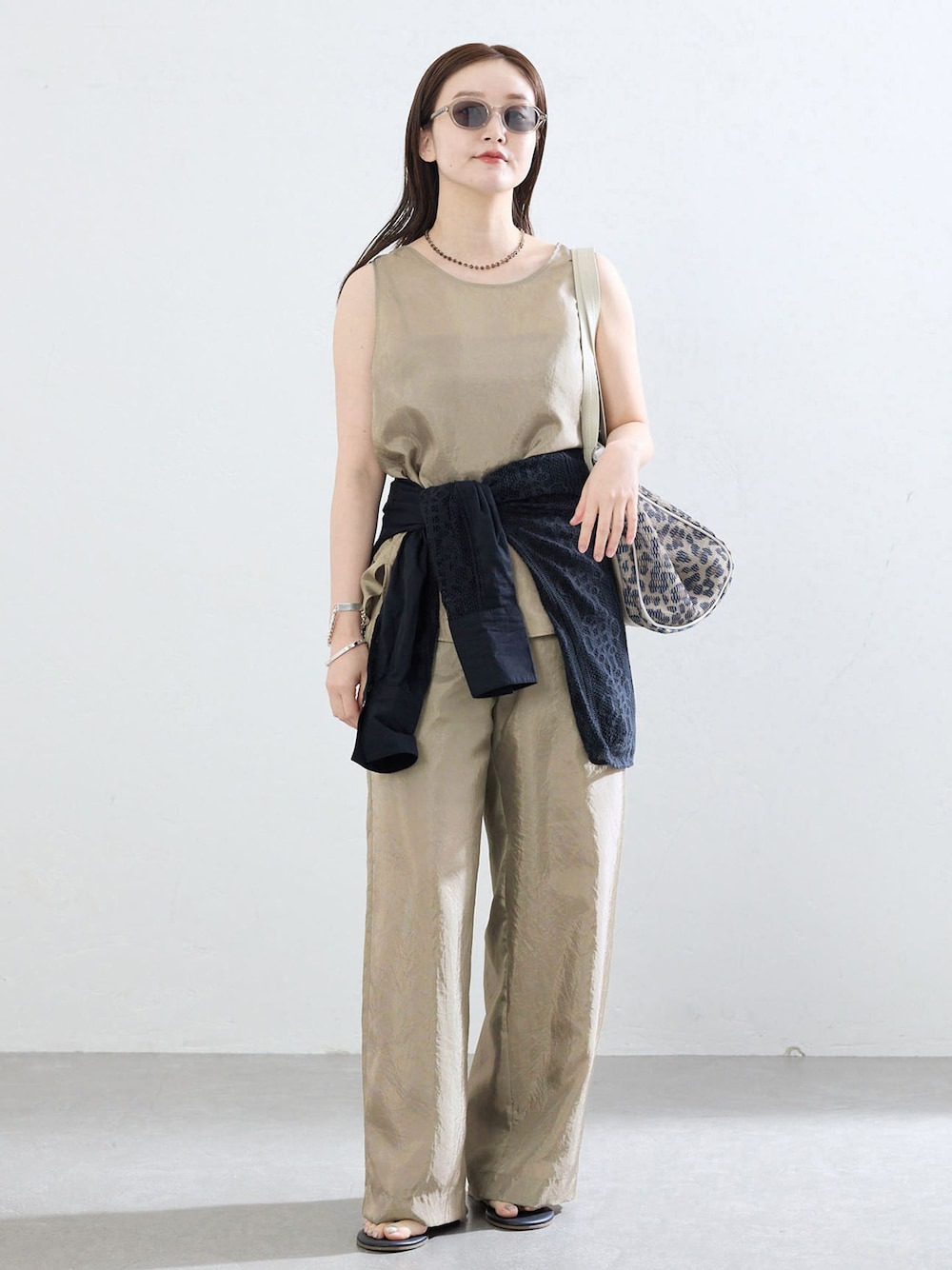 ベージュ系のその他パンツ、ベージュ系のシャツ/ブラウス、ブラウン系のトートバッグを着用したレディースの夏コーディネートの1枚目の写真