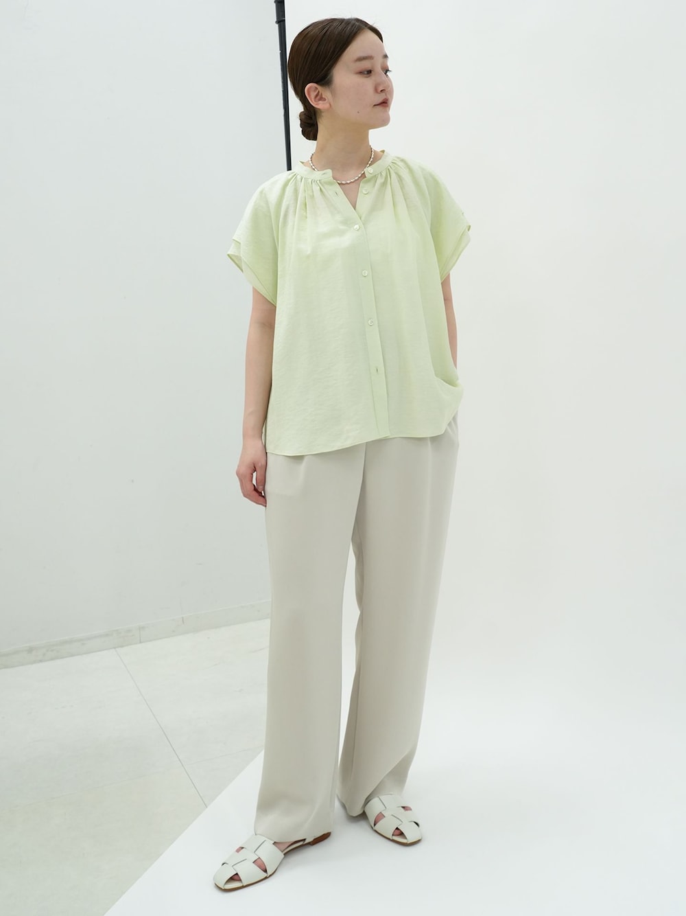 ベージュ系のその他パンツ、グリーン系のシャツ/ブラウス、ホワイト系のサンダルを着用したレディースの春コーディネートの1枚目の写真