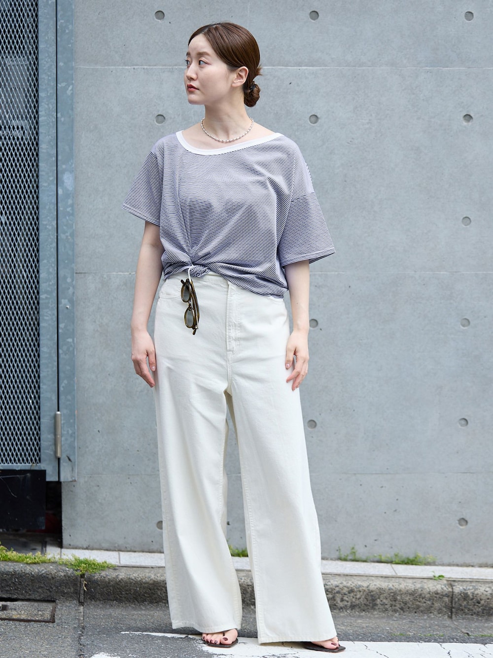 ホワイト系のチノパンツ、ブルー系のTシャツ/カットソー、ブラウン系のサンダルを着用したレディースの春コーディネートの1枚目の写真