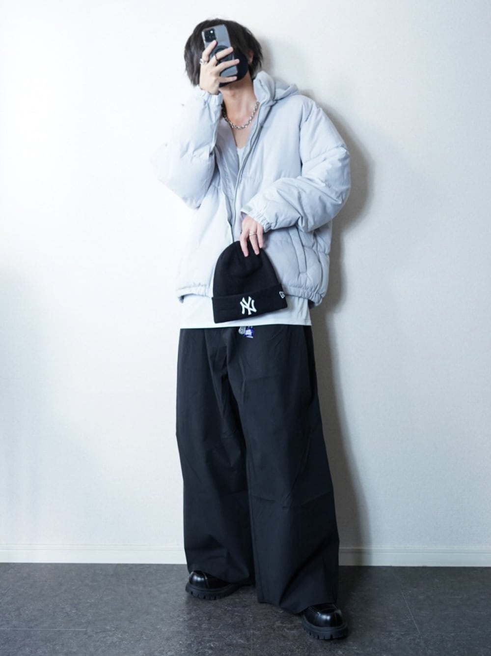 グレー系のダウンジャケット/コート、ブラック系のローファー、ブラック系のパンツを着用したメンズの秋コーディネートの1枚目の写真