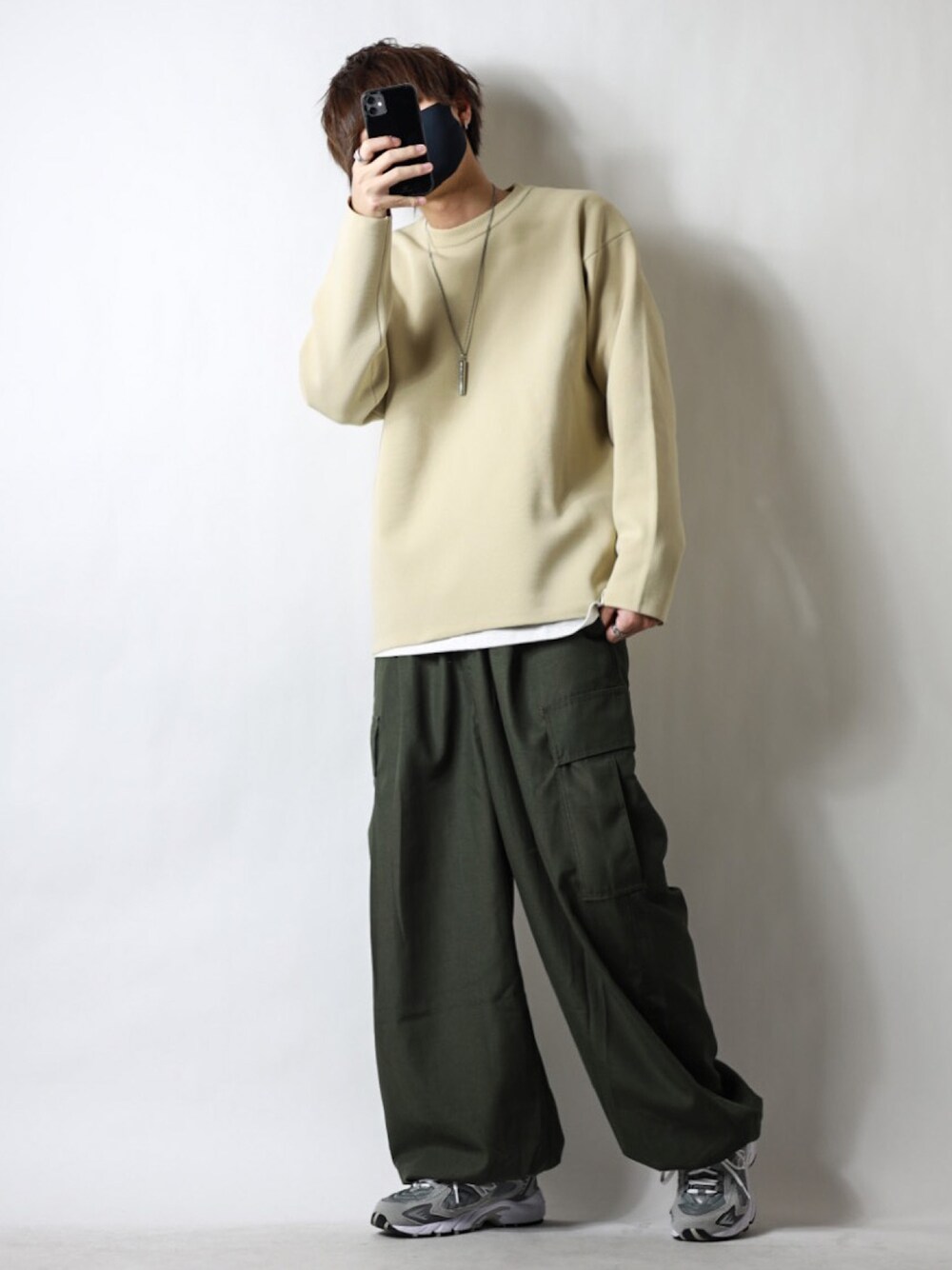 ベージュ系のニット/セーター、グリーン系のその他パンツ、グレー系のスニーカーを着用したメンズの春コーディネートの1枚目の写真