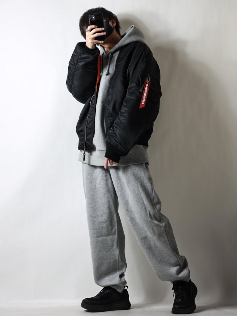 ブラック系のMA-1、グレー系のパーカー、グレー系のスウェットパンツを着用したメンズの冬コーディネートの1枚目の写真
