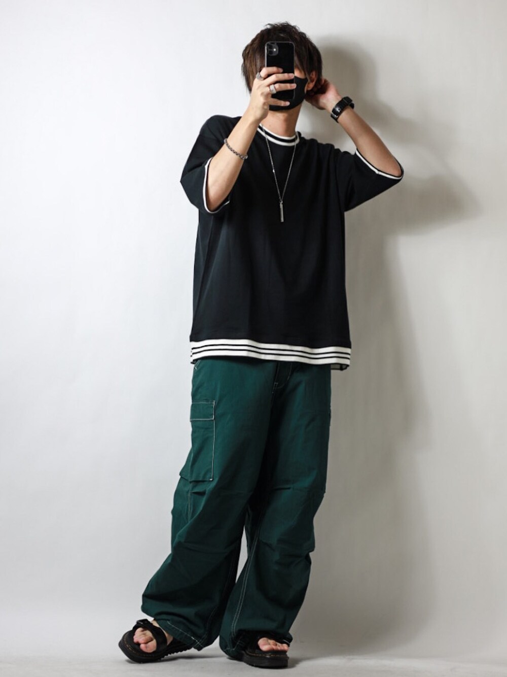ブラック系のTシャツ/カットソー、グリーン系のデニムパンツ、ブラック系のサンダルを着用したメンズの夏コーディネートの1枚目の写真