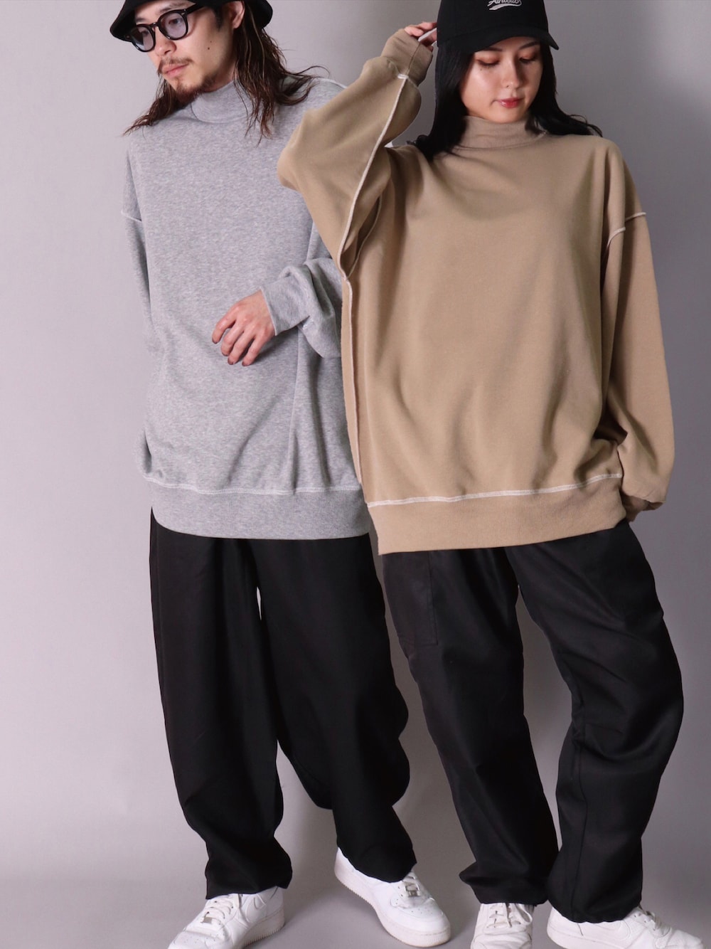グレー系のスウェット、ベージュ系のスウェット、ブラック系のカーゴパンツを着用したレディースの冬コーディネートの1枚目の写真