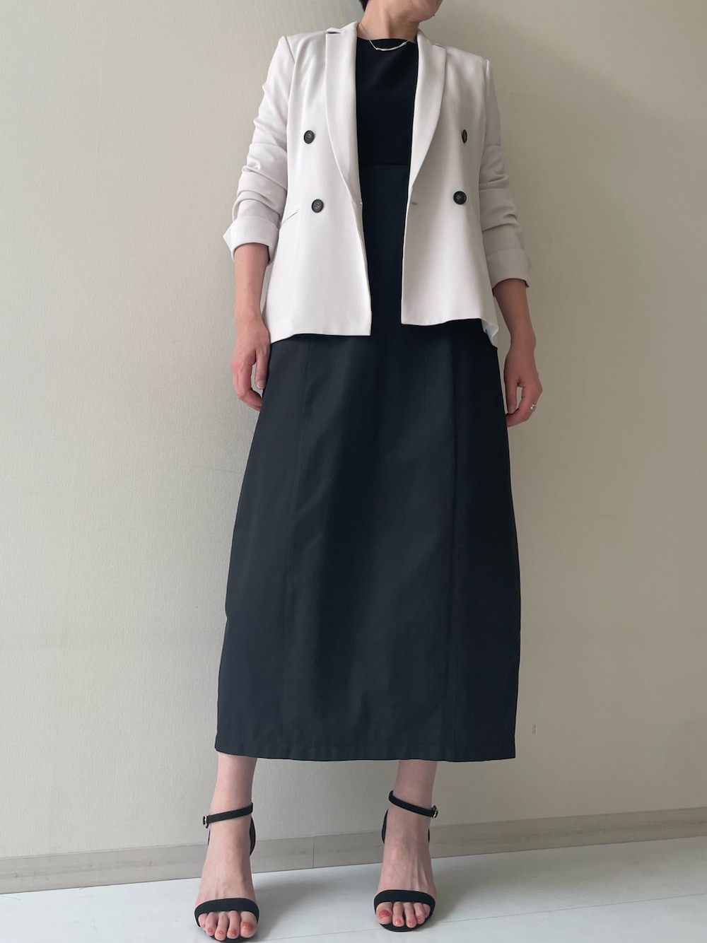 ベージュ系のジャケット/アウター、ブラック系のワンピースを着用したレディースの春コーディネートの1枚目の写真