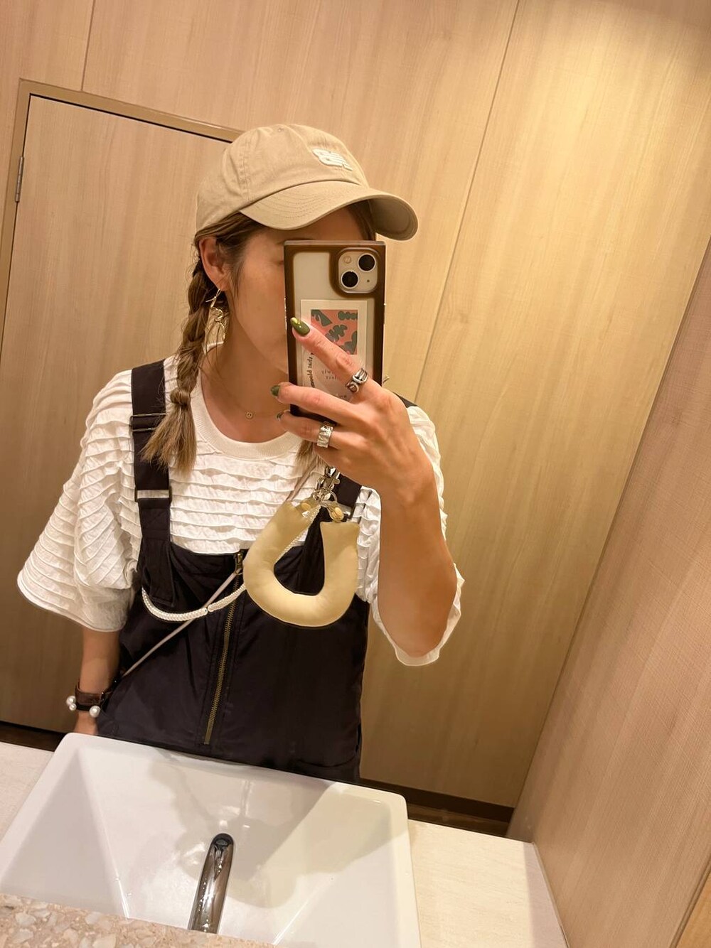 ベージュ系のキャップを着用したレディースの夏コーディネートの1枚目の写真
