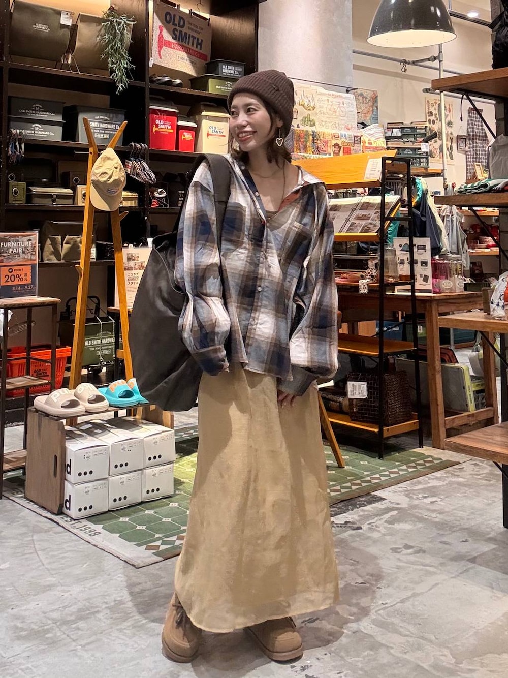 ブラウン系のショルダーバッグ、イエロー系のモカシン/デッキシューズ、ブラウン系のニットキャップ/ビーニーを着用したレディースの秋コーディネートの1枚目の写真
