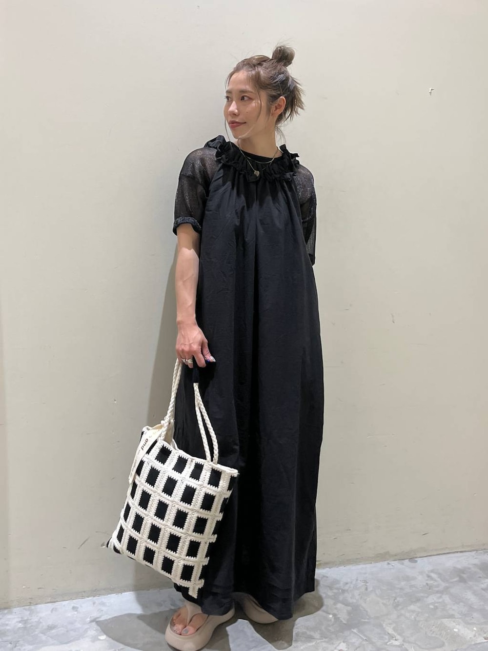 ベージュ系のサンダル、ブラック系のワンピース、ブラック系のトートバッグを着用したレディースの春コーディネートの1枚目の写真